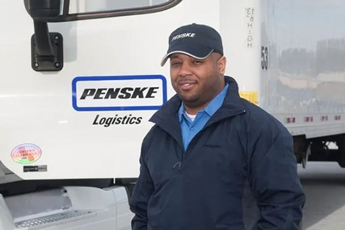Driver standing next to Penske truck