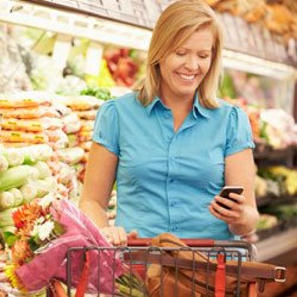 Woman grocery shopping with phone