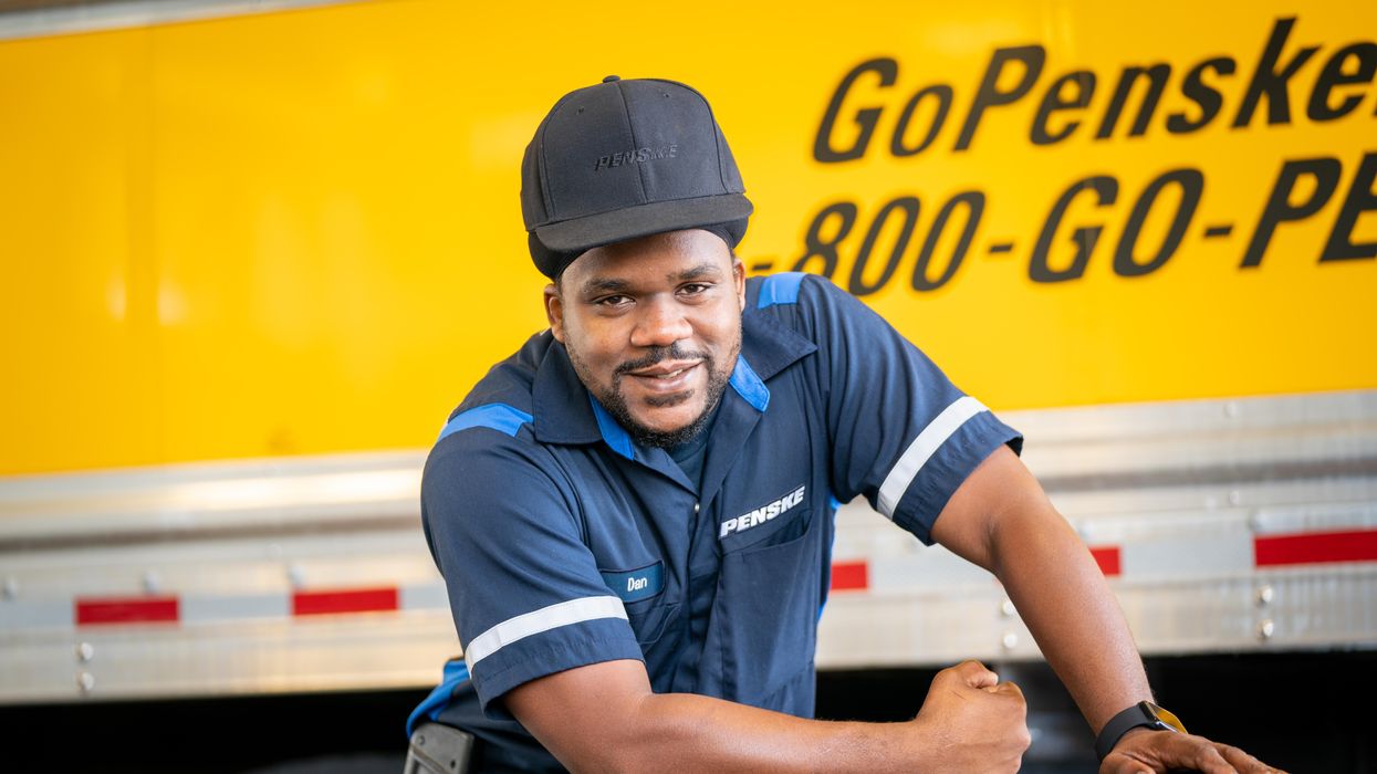 Penske technician posed in front of a Penske truck 