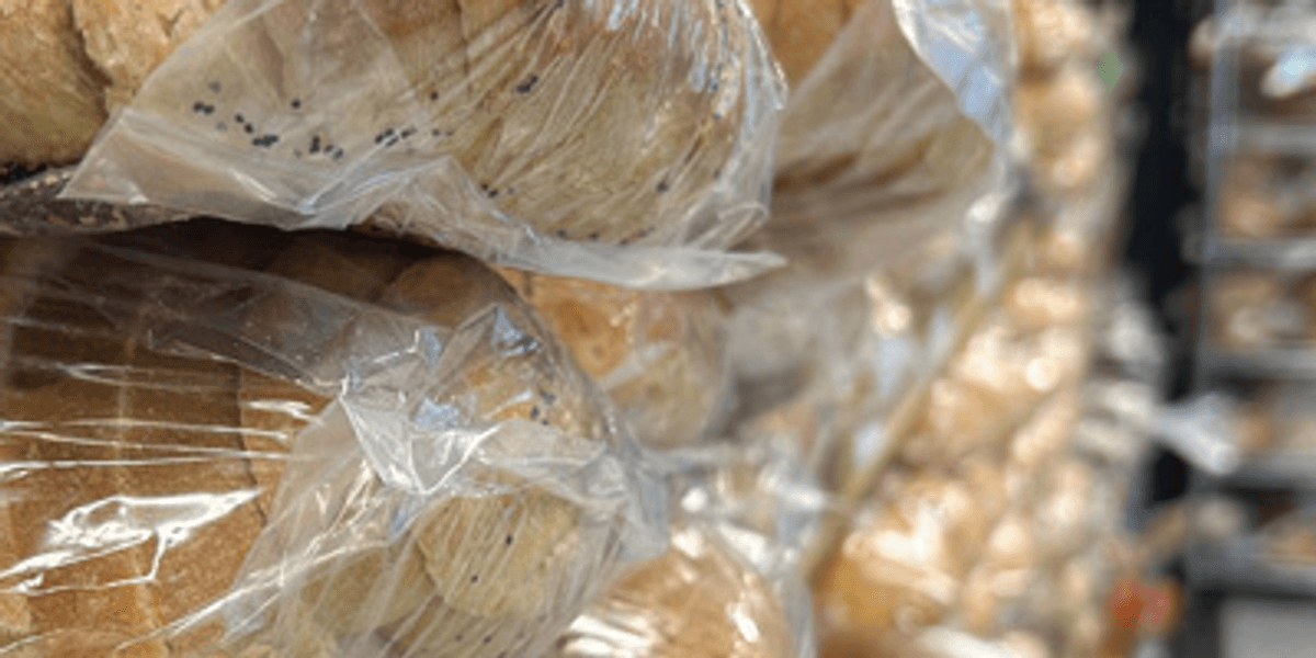 Loaves of bread wrapped in clear plastic and stacked