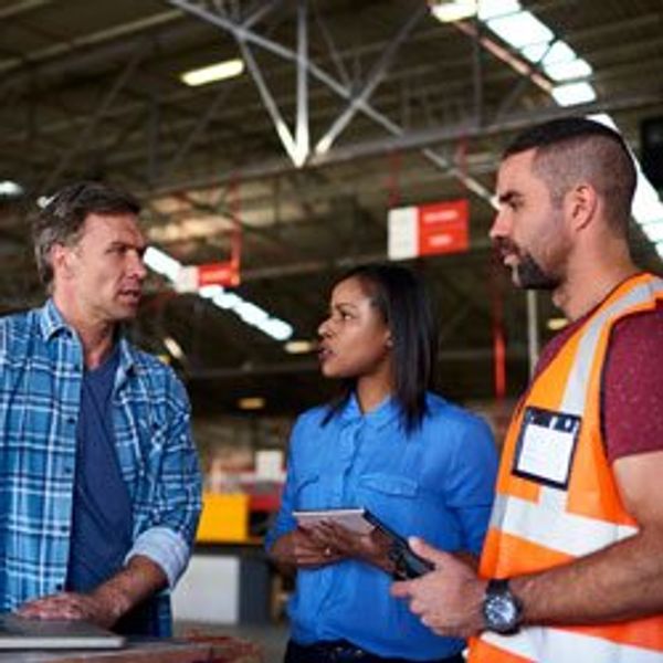 Three people in a warehouse