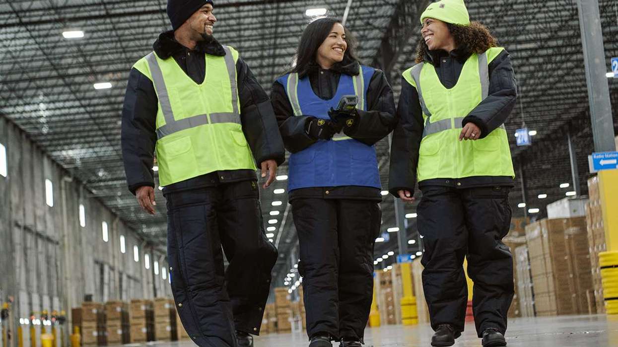 Three warehouse associates walking in a warehouse and talking