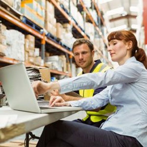 Two men looking at laptop in a warehouse