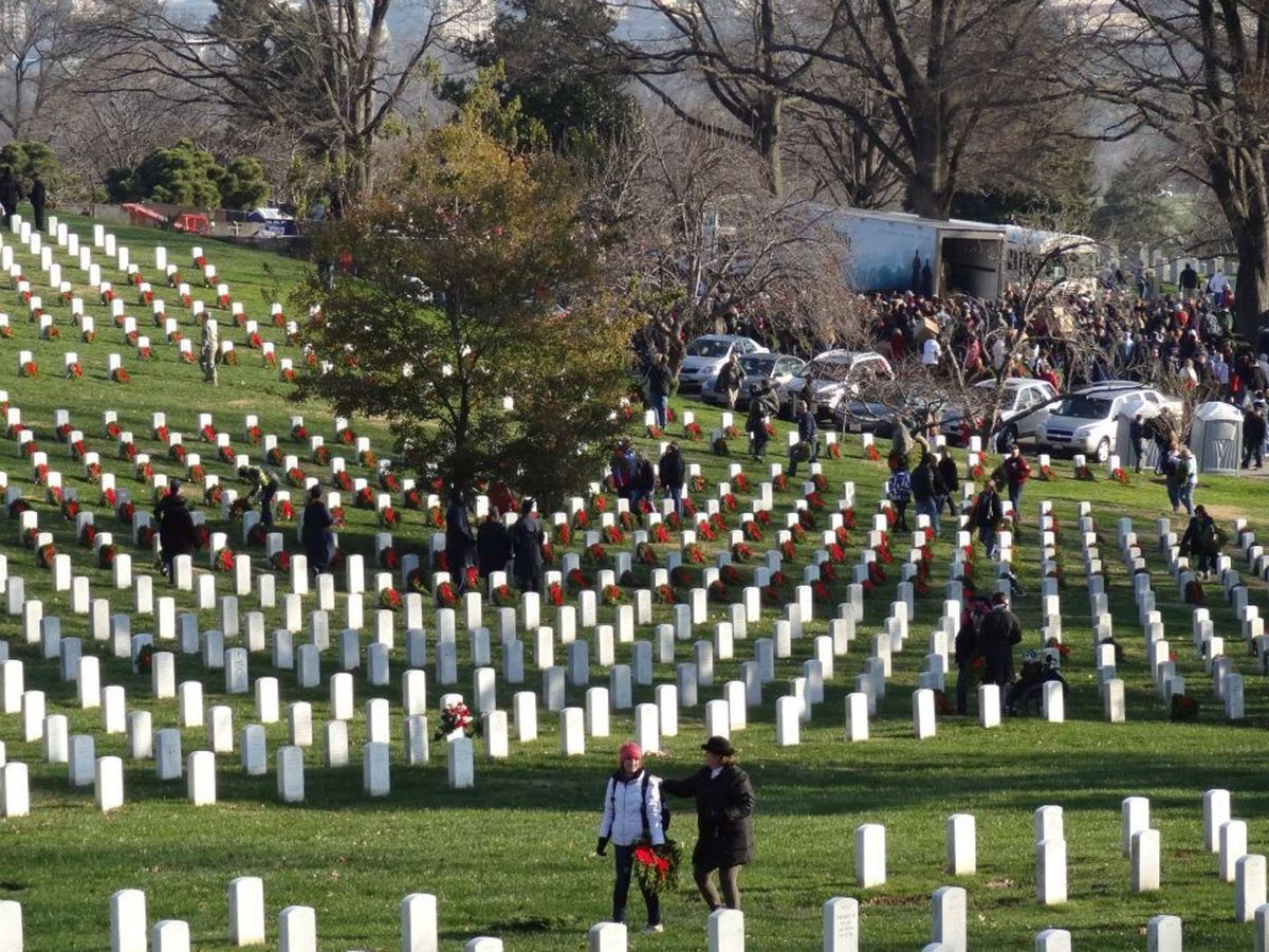 Two people lay wreaths at Arlington National Cemetery