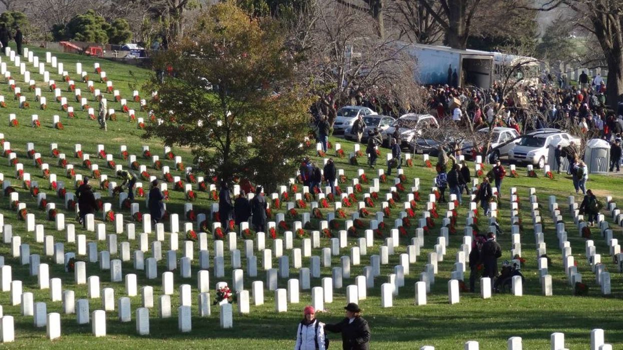 Two people lay wreaths at Arlington National Cemetery