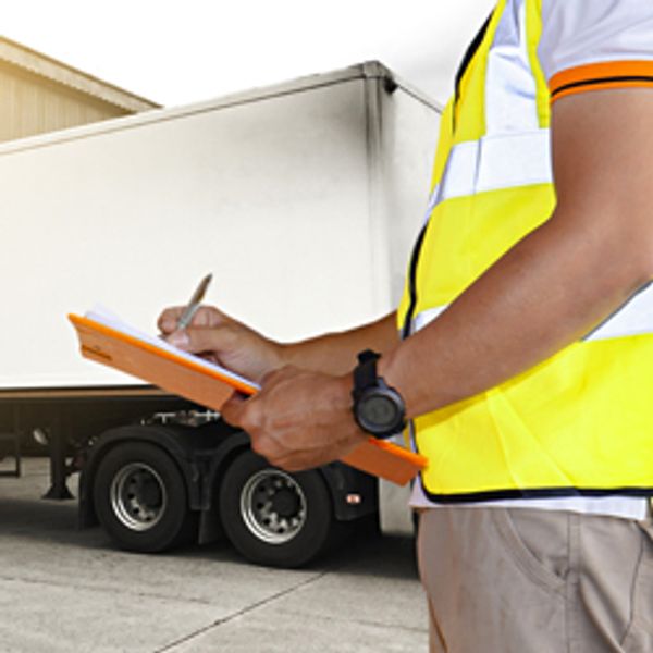 Worker with clipboard at loading dock